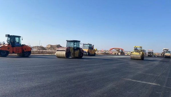 近日，在西部市政建設(shè)集團蘭州新區(qū)城市礦產(chǎn)與表面處理產(chǎn)業(yè)園區(qū)（二期）周邊基礎(chǔ)設(shè)施項目—園區(qū)西路南延段（緯五十路至緯二十八路）項目現(xiàn)場，隨著一輛輛運料車平穩(wěn)駛?cè)?，攤鋪機將滾燙的瀝青混合料均勻鋪開，標(biāo)志著項